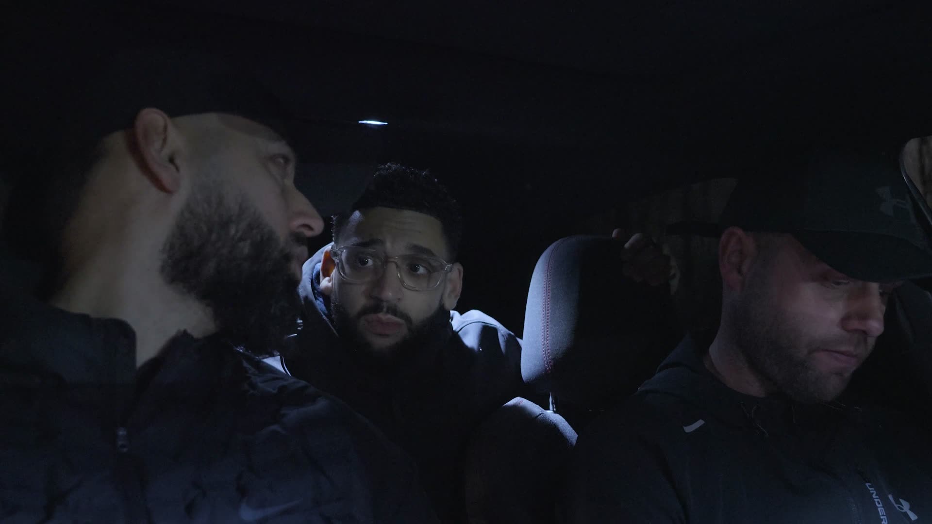 Still uit de trailer: drie mannen achterin een auto bij nacht