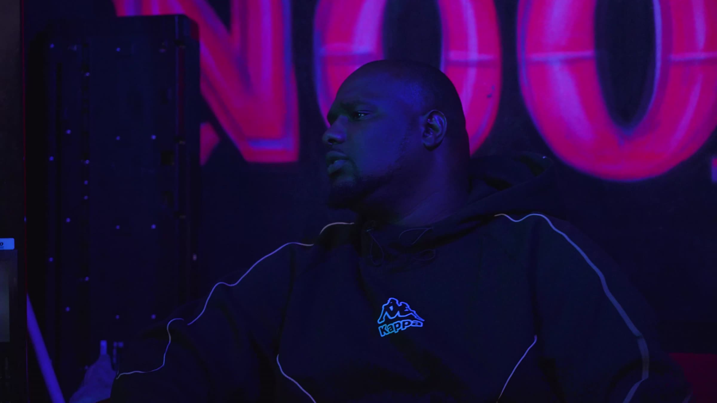 Still uit de trailer: man onder roze neonlicht